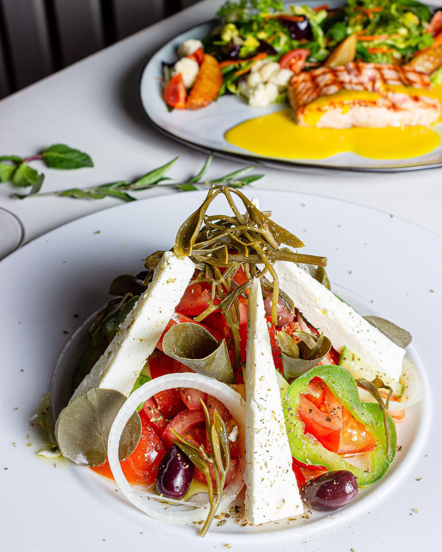A plate of Mediterranean salad with feta cheese, olives, and vegetables.