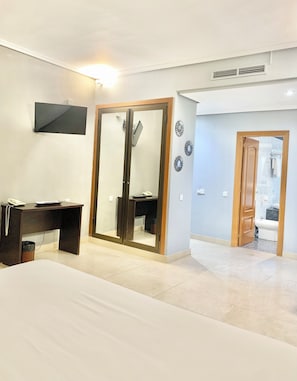 A bedroom with a bed, a desk, a wardrobe, and a bathroom visible through an open door. - Hotel Humanes (Humanes de Madrid)