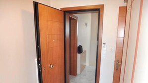 Un pasillo con una puerta de madera y una pared blanca.