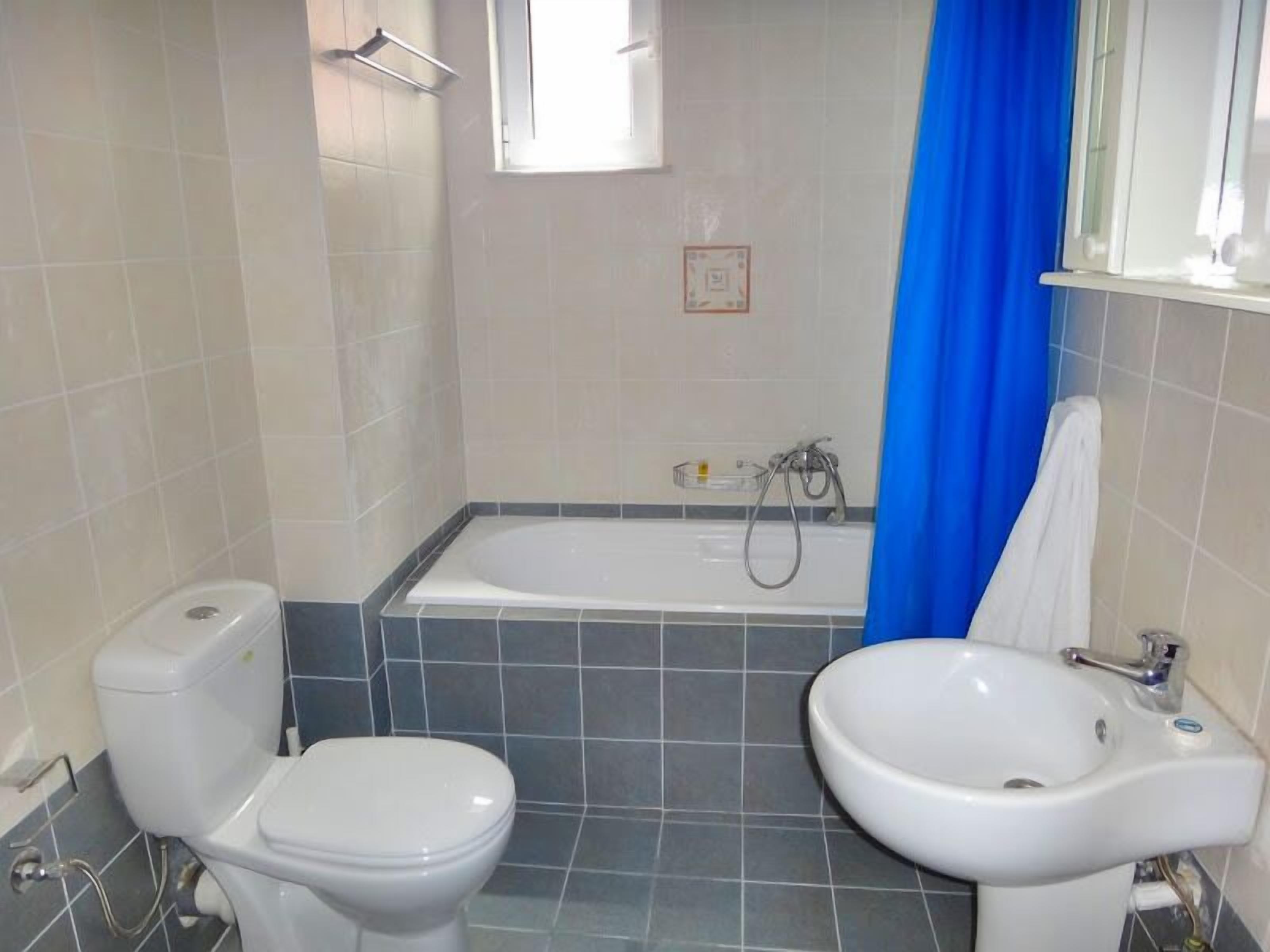 Une salle de bain comprenant des toilettes, un bidet, une baignoire et un lavabo.