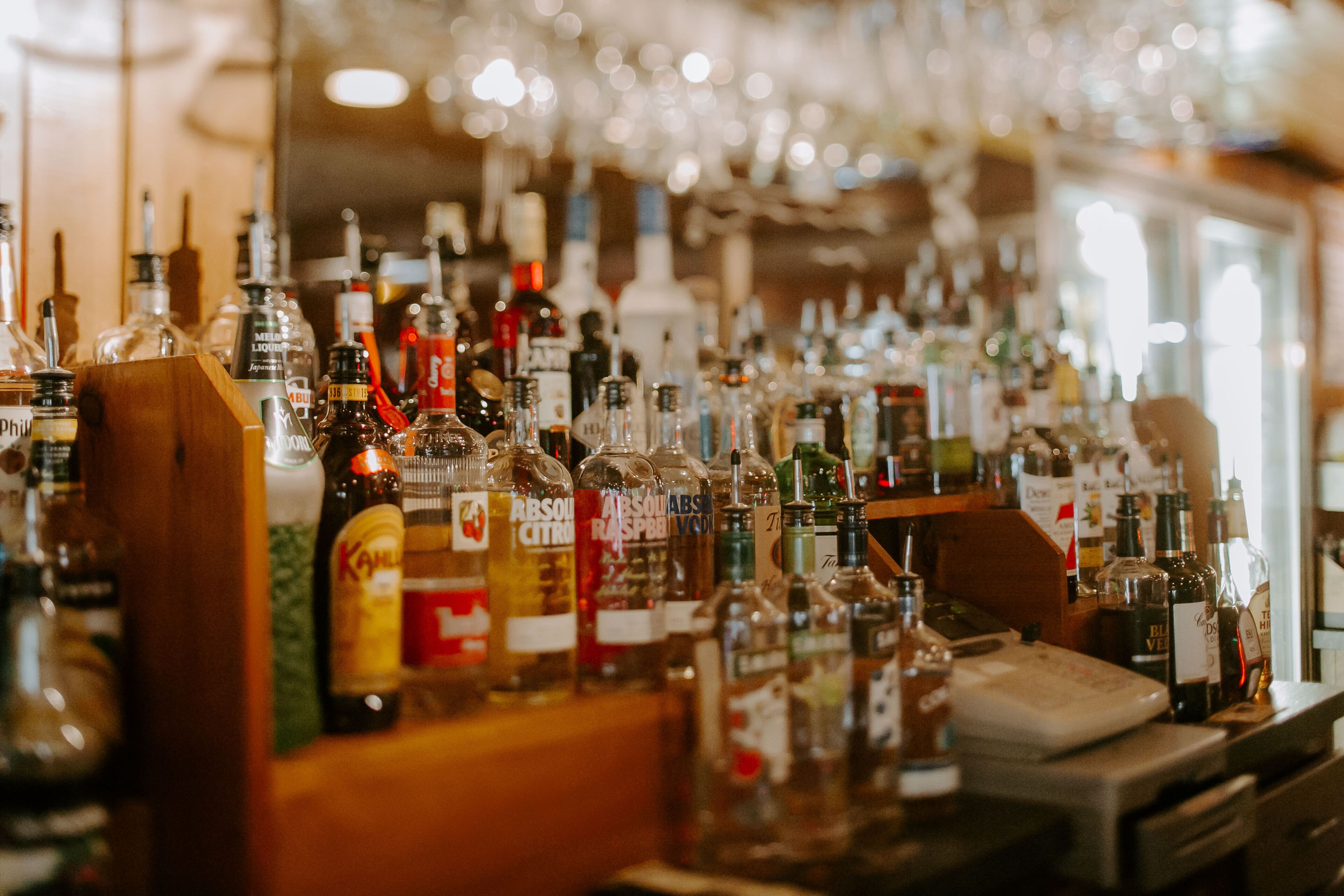 Un bar où l’on trouve une grande variété de bouteilles d’alcool et de verres.