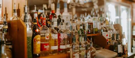 Un bar con una variedad de botellas de licor y vasos.