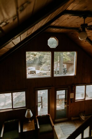 A cabin with a sloped roof, large windows, and a wooden interior. - Silver Rapids Lodge (Ely)