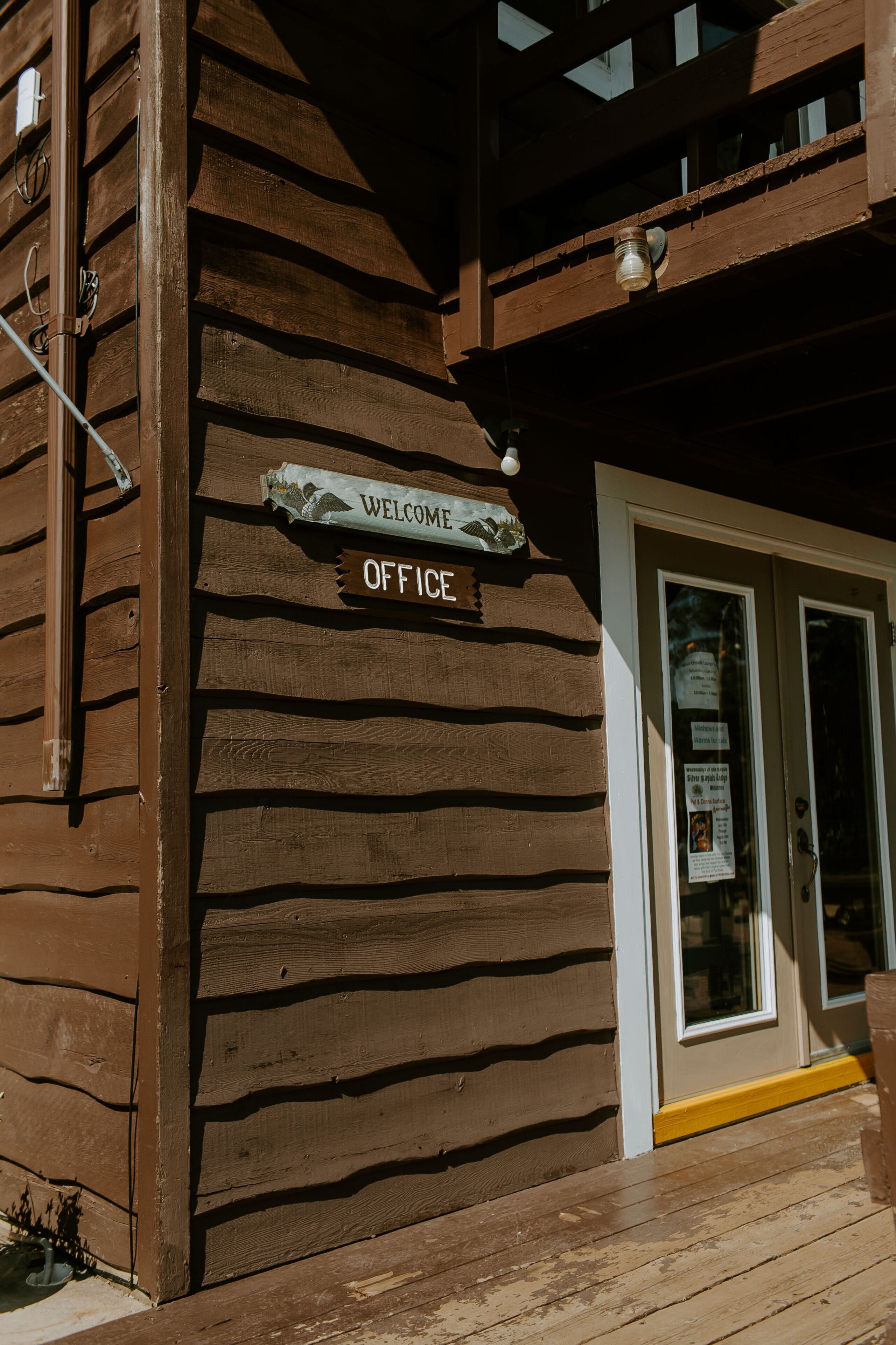 Un bâtiment en bois avec une enseigne indiquant « Bureau d’accueil ».