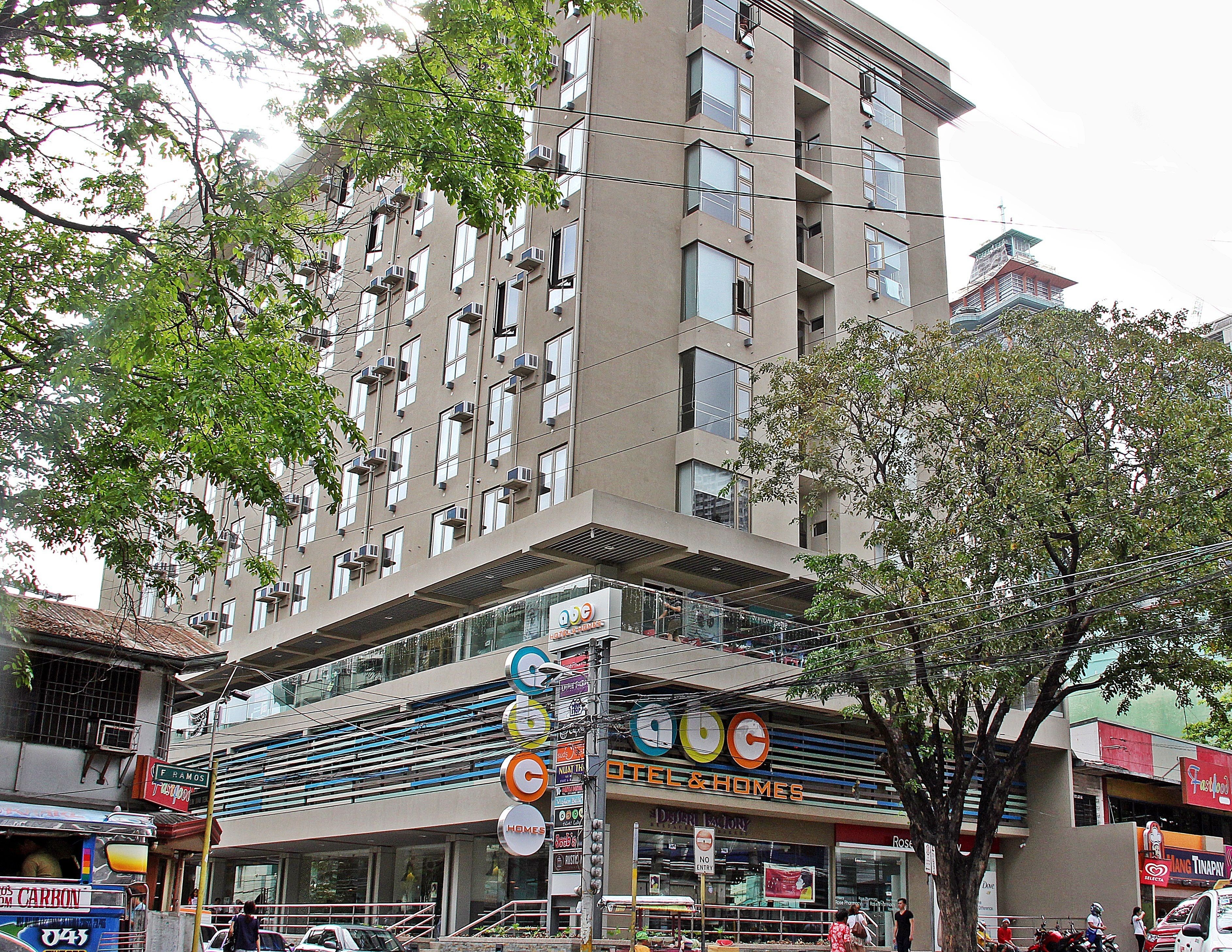 A multi-story hotel with balconies and a ground-level retail space.