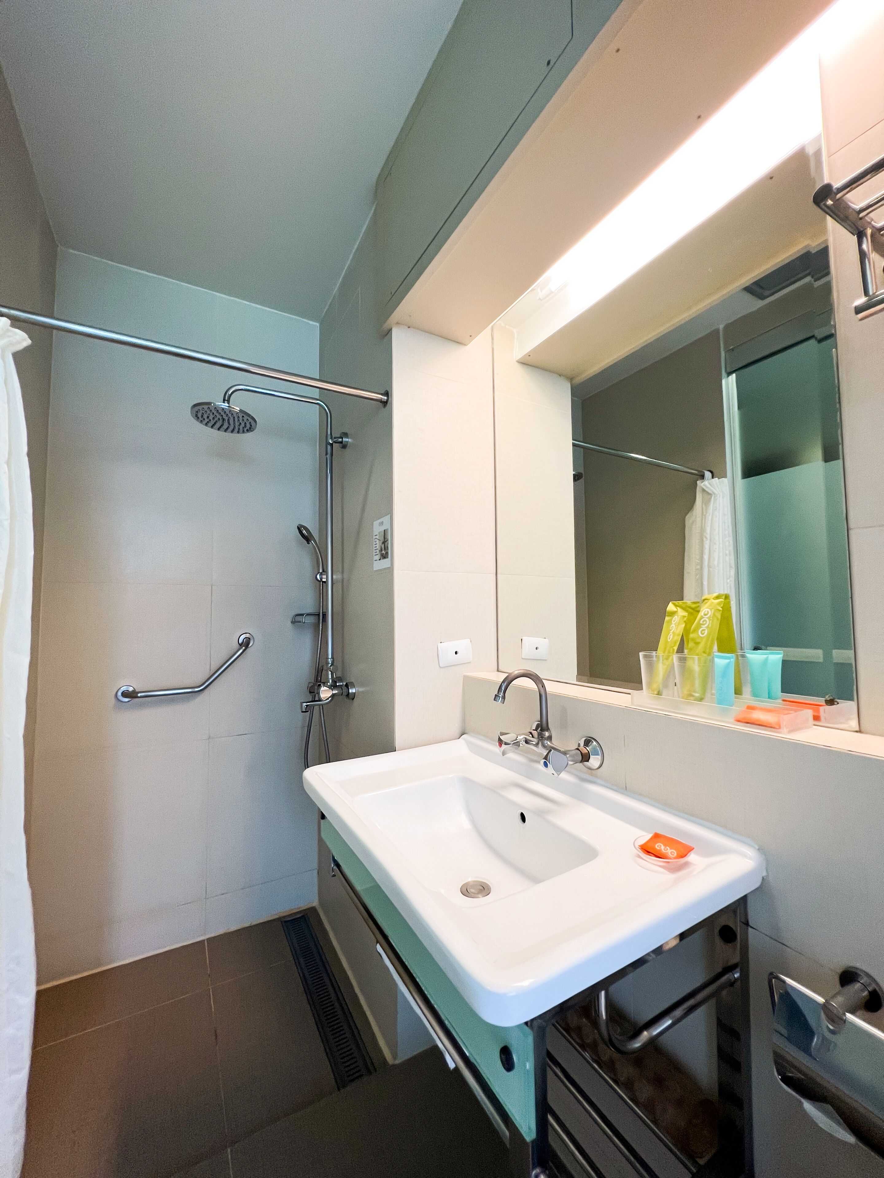 A bathroom with a shower, a sink, and a mirror.