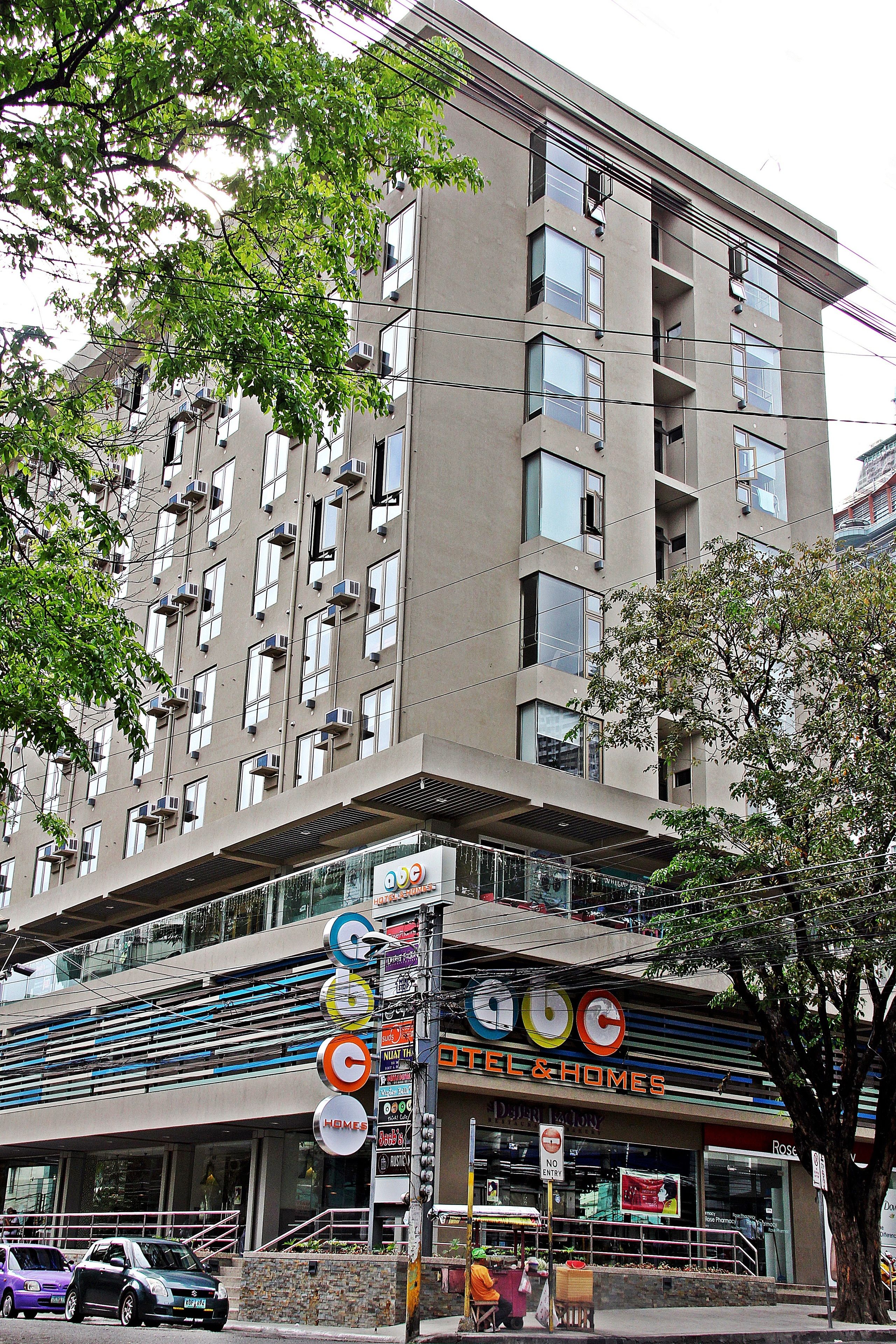 Un edificio de varios pisos con escaparate de un hotel y una tienda de artículos para el hogar.