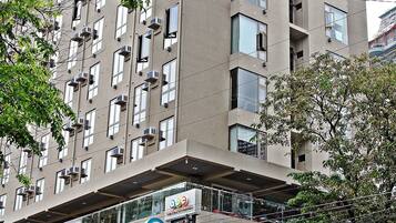 Un edificio de varios pisos con escaparate de un hotel y una tienda de artículos para el hogar.