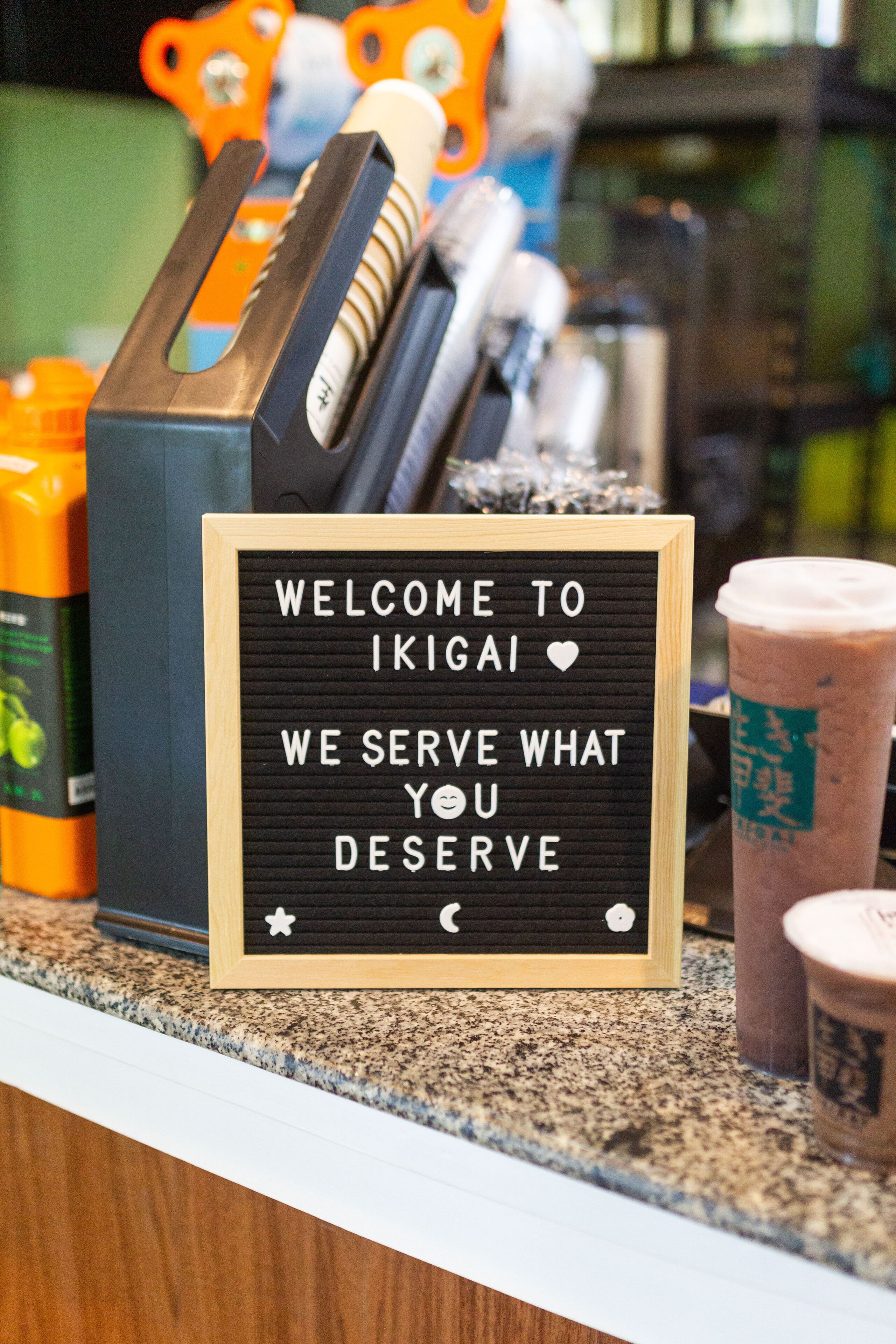 Un letrero en una barra dice: "BIENVENIDOS A IKIGAI, SIRVIMOS LO QUE TE MERECE".