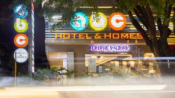 A hotel named 'HOTEL & HOMES' with a 'DEFIANT FACTORY' sign.