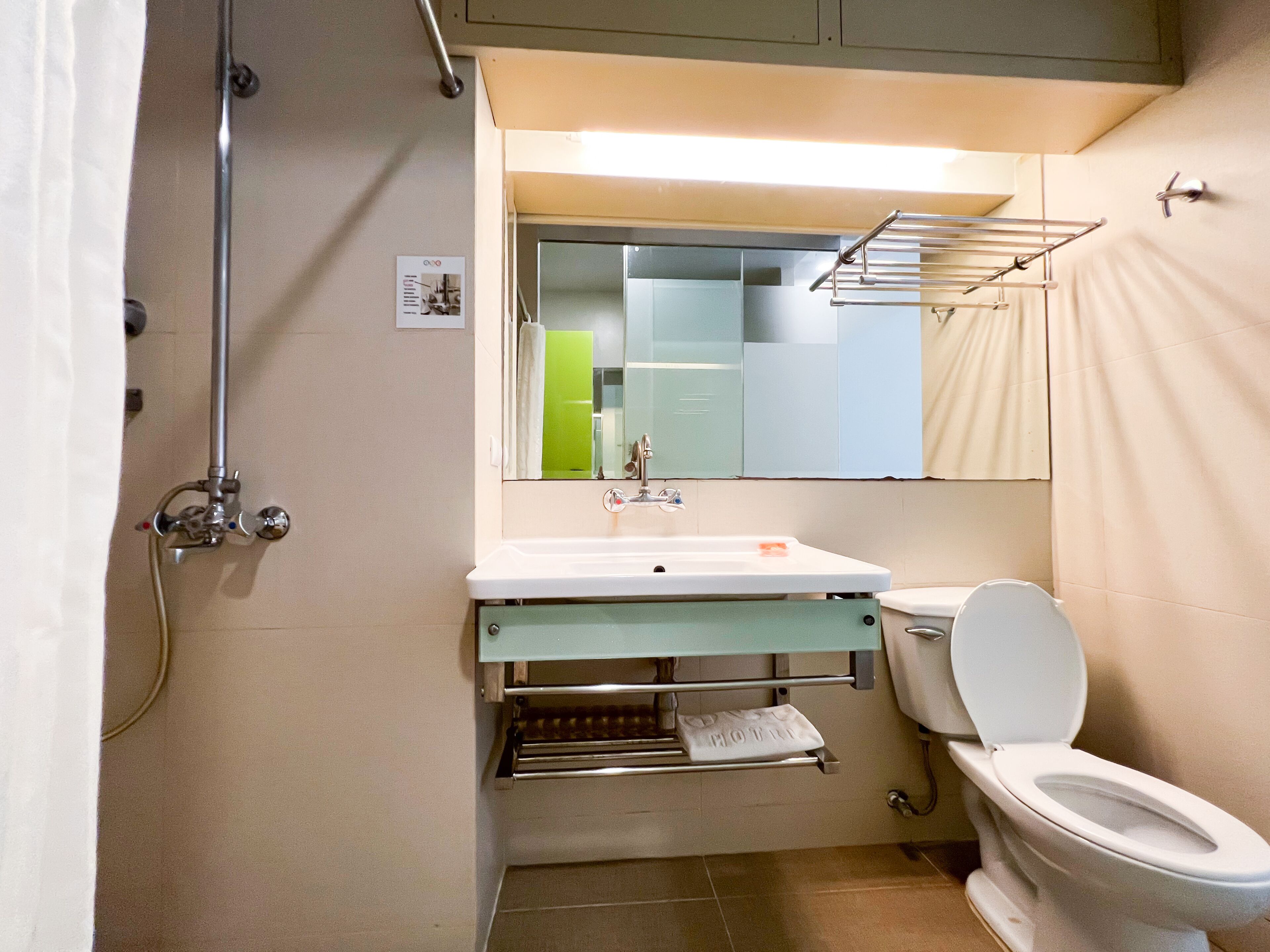 A compact bathroom with a shower, sink, and toilet.