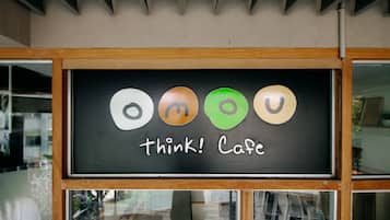 A cafe sign with the name "omou" and the tagline "think! Cafe" displayed on a blackboard.