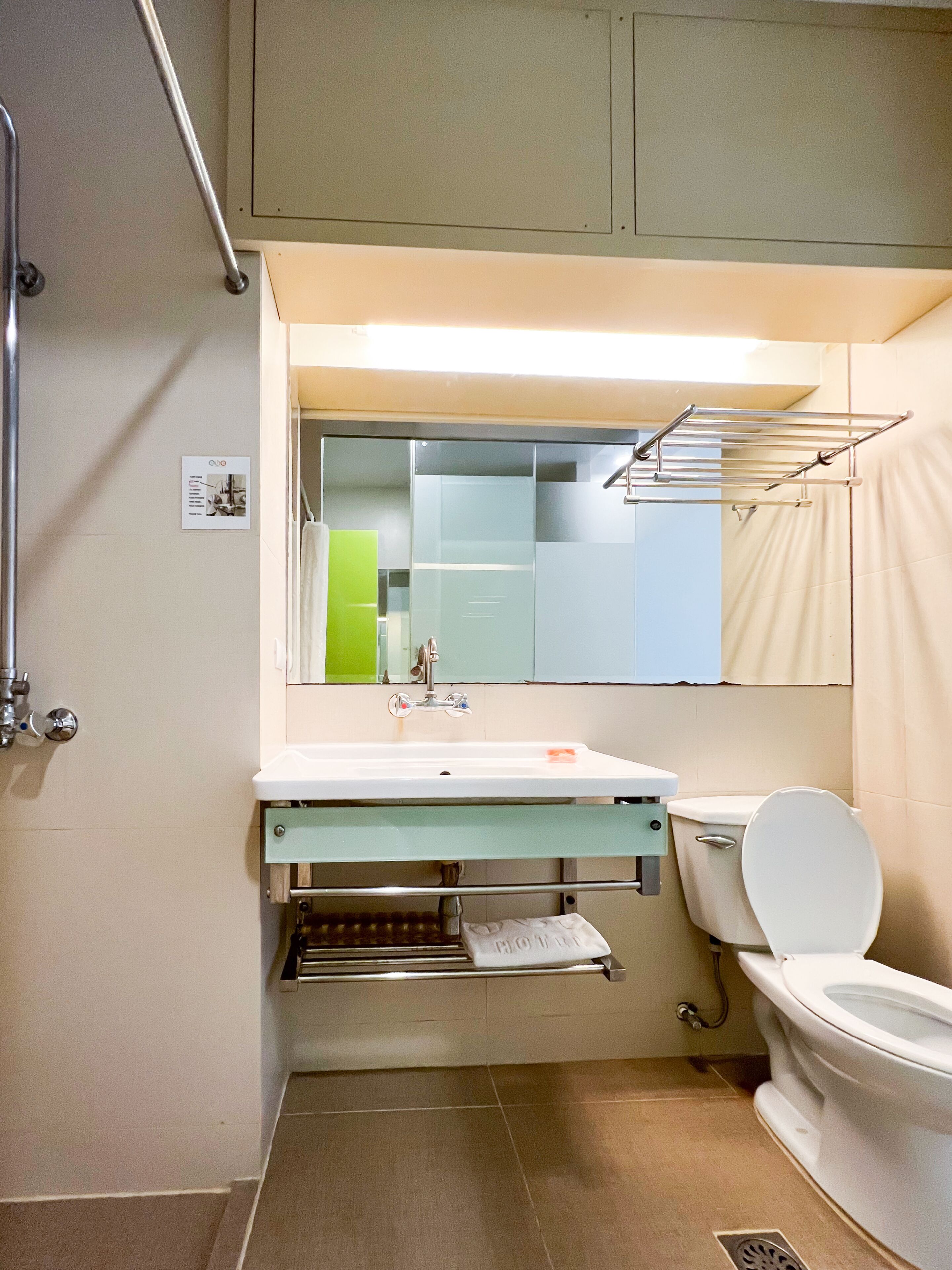 Un baño pequeño con lavamanos, inodoro y espejo sobre el lavamanos.