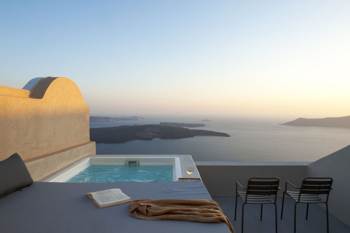 Un balcón con vistas al mar, un jacuzzi y un espacio de estar.