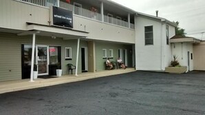 A two-story motel with a covered front porch and a small outdoor seating area. - Wheel Inn Motel (Temiskaming Shores)