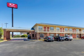 A motel with a red sign, a covered parking area, and several cars parked in front. - Econo Lodge Athens I-75 (Athens)