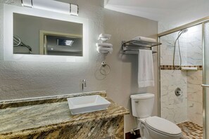 A bathroom with a marble sink, a toilet, a glass shower enclosure, and a towel rack. - Econo Lodge Athens I-75 (Athens)