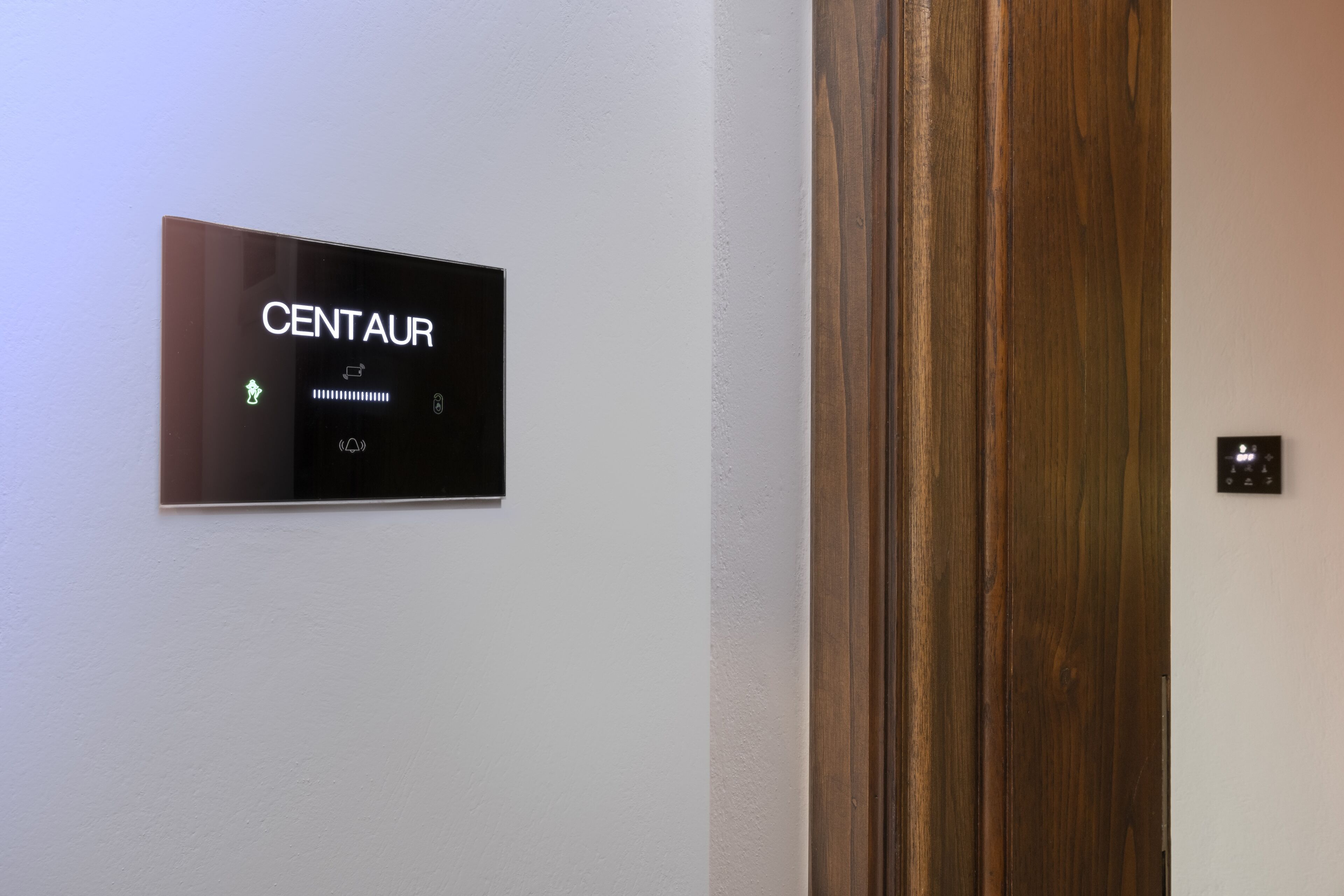 Un letrero en la pared con el nombre "CENTAU" y símbolos que indican los servicios.
