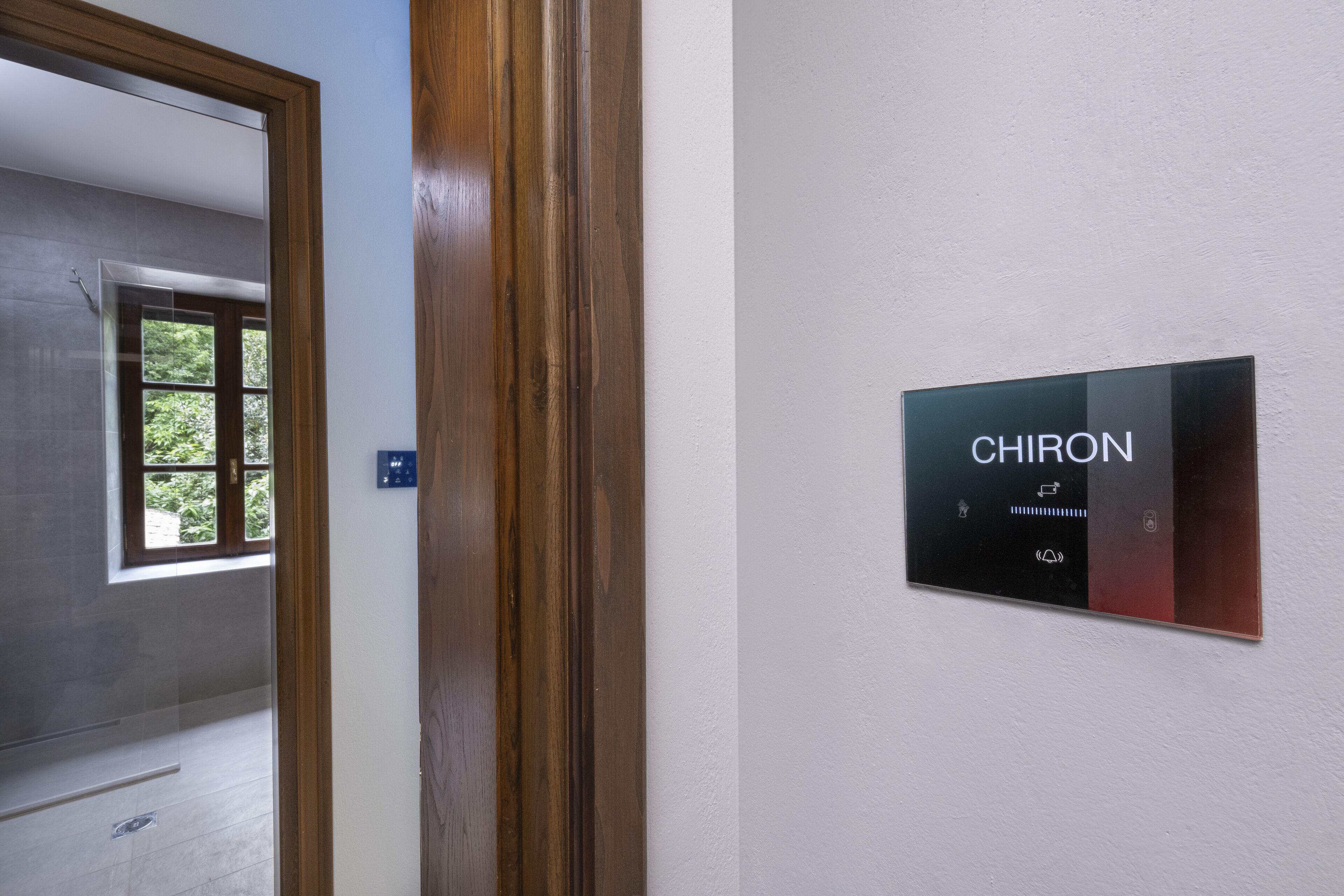 Un pasillo con un marco de puerta de madera y un cartel en la pared que dice 'CHIRON'.