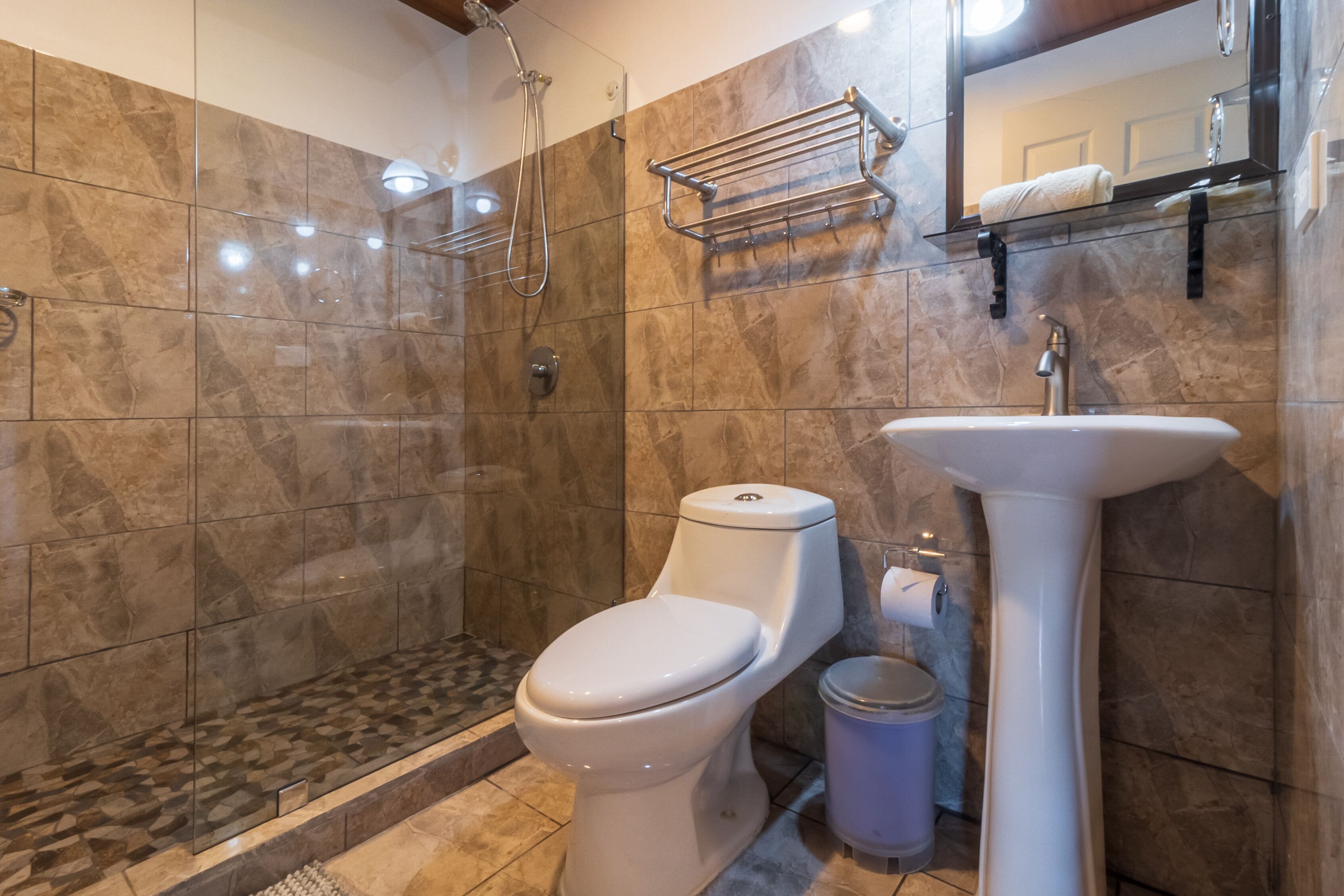 Un baño moderno con ducha, inodoro y lavamanos.