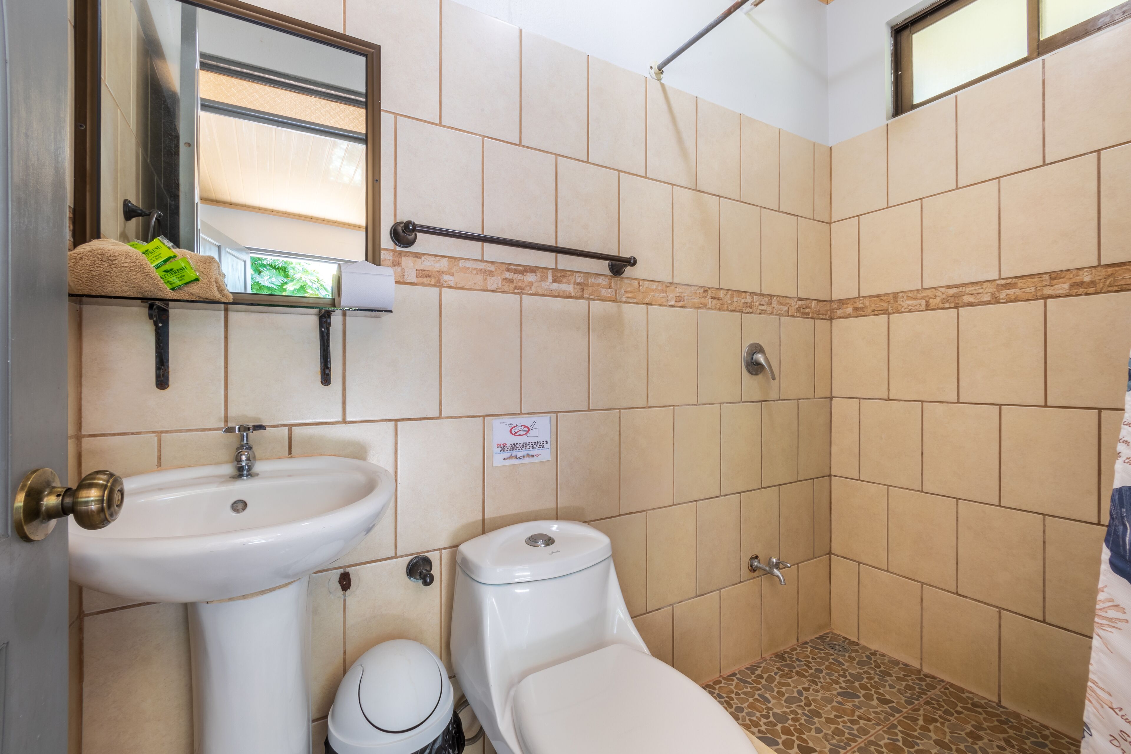 A bathroom with a sink, toilet, and shower area.