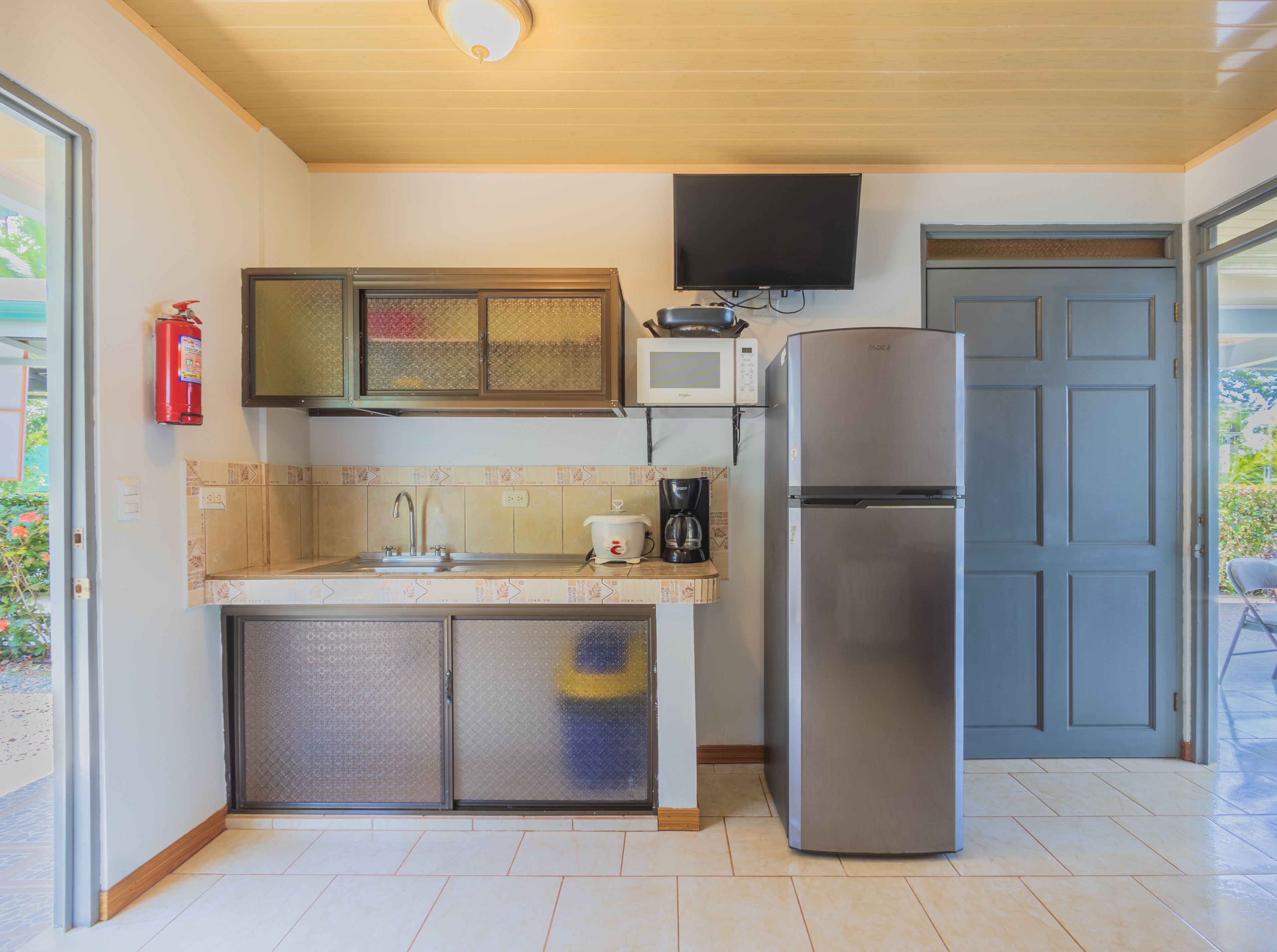 Una cocina compacta equipada con microondas, estufa y refrigerador.