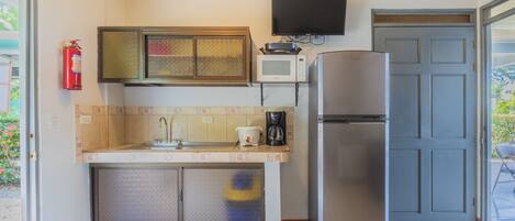 Una cocina compacta equipada con microondas, estufa y refrigerador.
