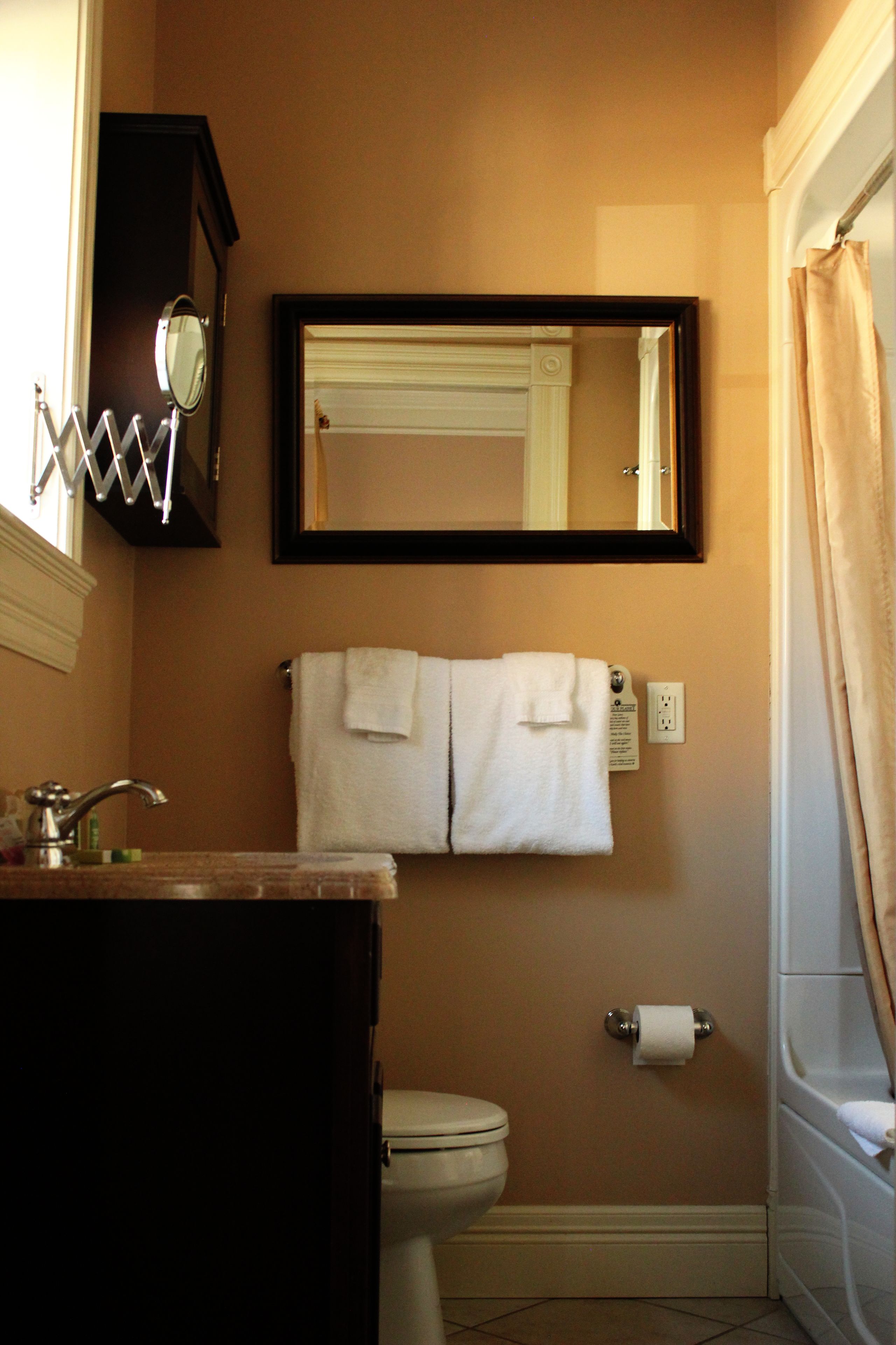 A bathroom with a sink, mirror, toilet, and bathtub.
