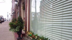 A building with a brick facade, a small Christmas tree, and festive decorations on the window sill. - Chipman Hill Suites on Union (Saint John)