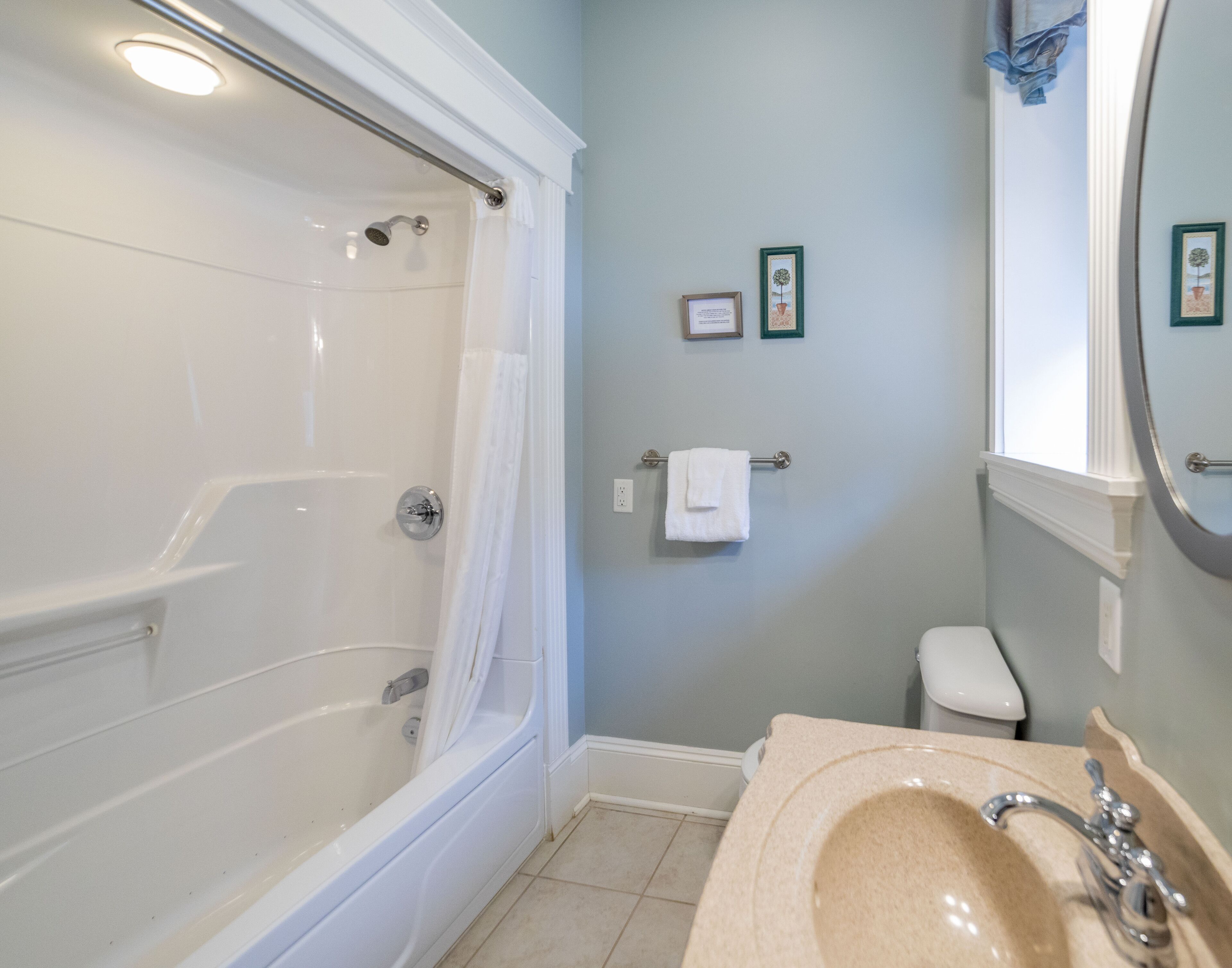 A bathroom with a bathtub, toilet, sink, and a shower curtain.