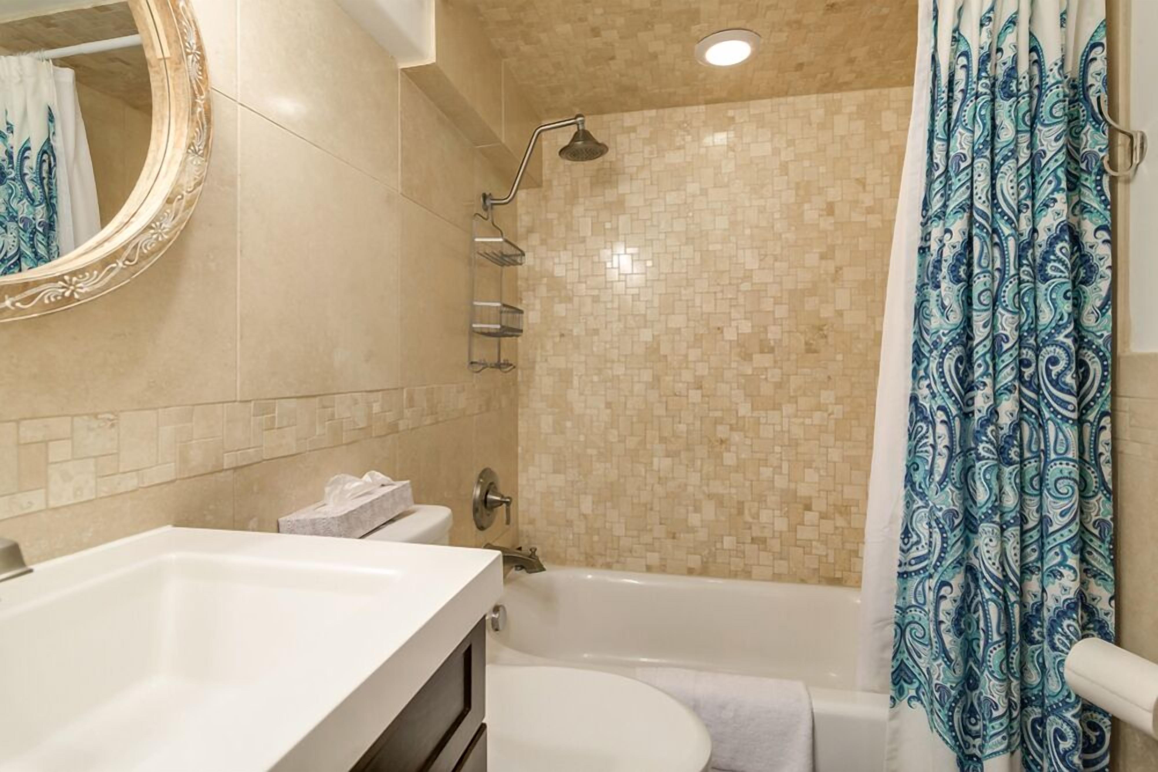 A bathroom with a bathtub, a shower, a toilet, and a sink.