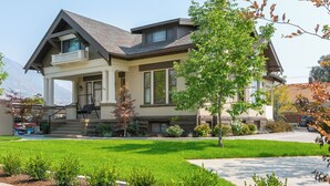 A two-story house with a large front porch, a covered entryway, and a well-maintained lawn. - Aspenwood Manor South (Provo)