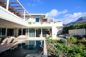 A modern house with a swimming pool, outdoor seating, and a view of mountains. - Thirty on Grace (Cape Town)