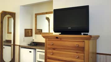 Una cocina compacta con un mueble de madera, un microondas y un refrigerador.