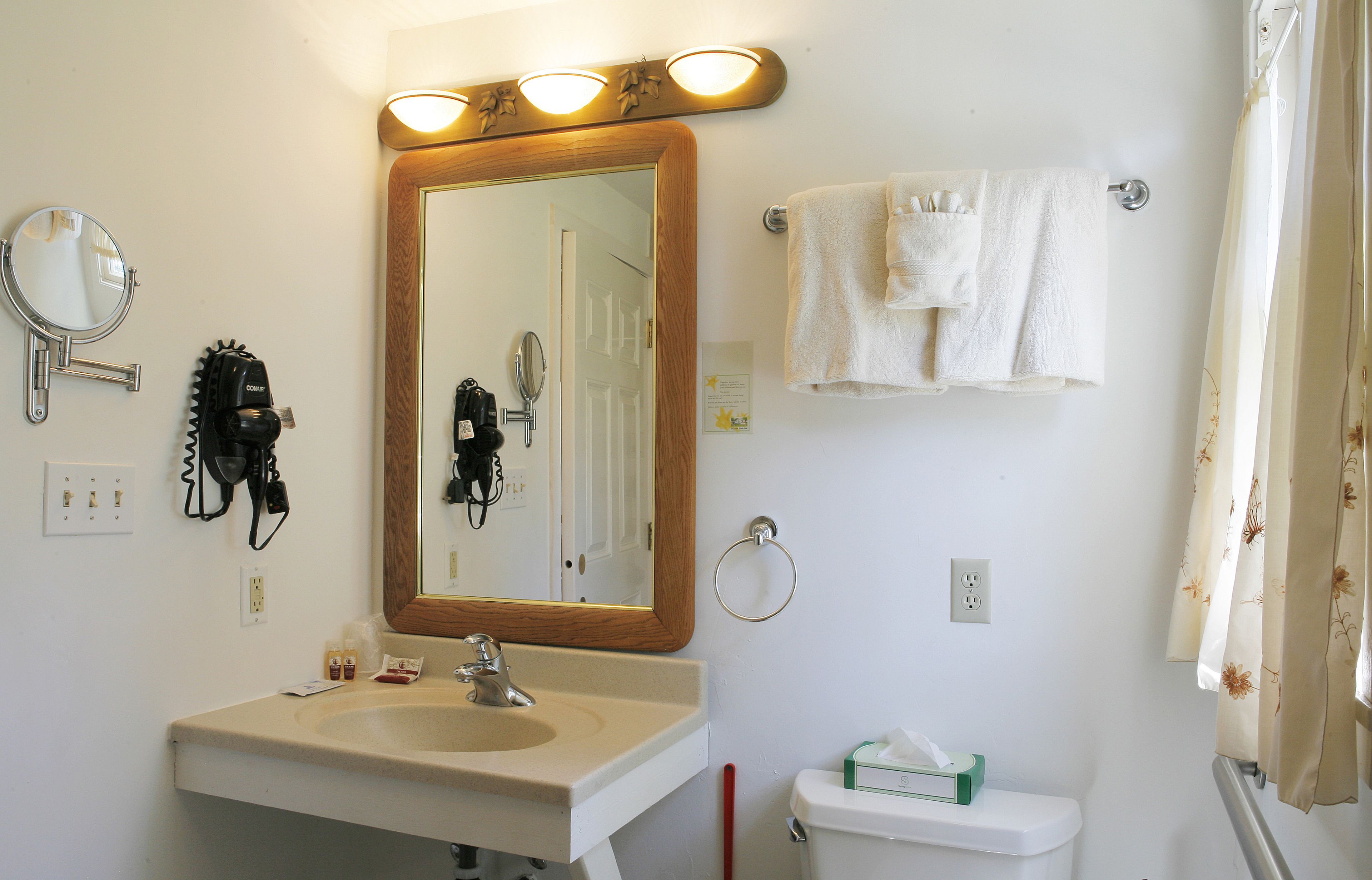 A bathroom with a sink, mirror, towel rack, and toilet.