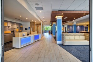 A hotel lobby with a reception desk, seating area, and a view of the outdoors. - Holiday Inn Express & Suites New Castle by IHG (New Castle)