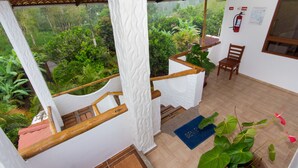 A room with a wooden staircase, a blue mat, and a potted plant. - Twin Hotel Galapagos (Bella Vista)
