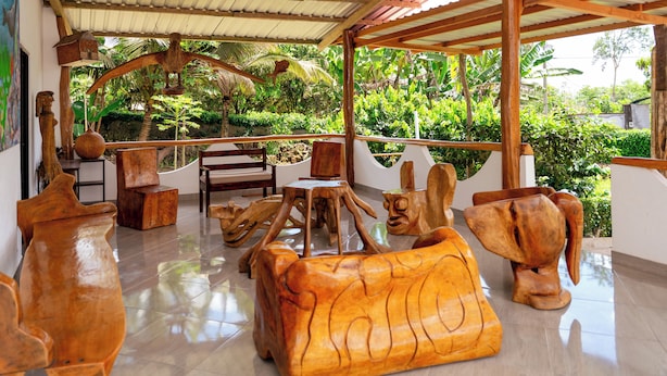 A wooden sculpture garden with benches and a covered seating area. - Twin Hotel Galapagos (Bella Vista)