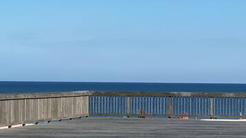 A wooden pier extending into a calm sea under a clear sky.