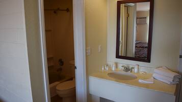 A bathroom with a white sink, mirror, and toilet.