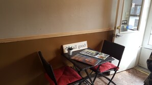 A small table with a 'All good' sign, a magazine, and a potted plant. - Trails End Motel (Lewistown)