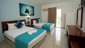 Habitación de hotel con dos camas, un escritorio, un televisor y una ventana con cortinas.