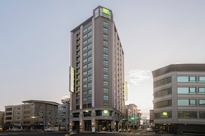 A multi-story hotel with a prominent 'Express' sign, a ground-level entrance, and a modern architectural design.