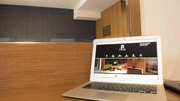 A laptop on a wooden desk displaying a hotel website.