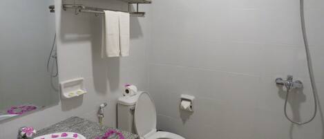 Un baño con lavamanos, inodoro y ducha.