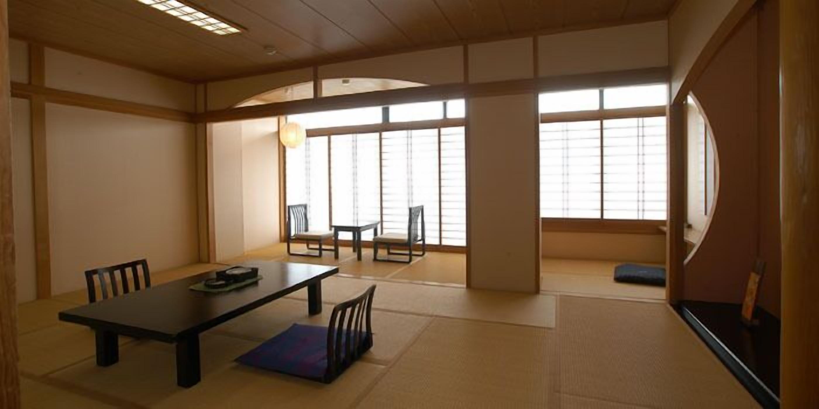A traditional Japanese room with tatami flooring, a low table, and sliding doors.