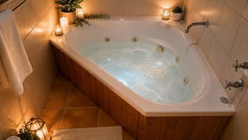 Une salle de bain moderne avec une baignoire sur pieds, un porte-serviettes, un lavabo et une plante en pot.