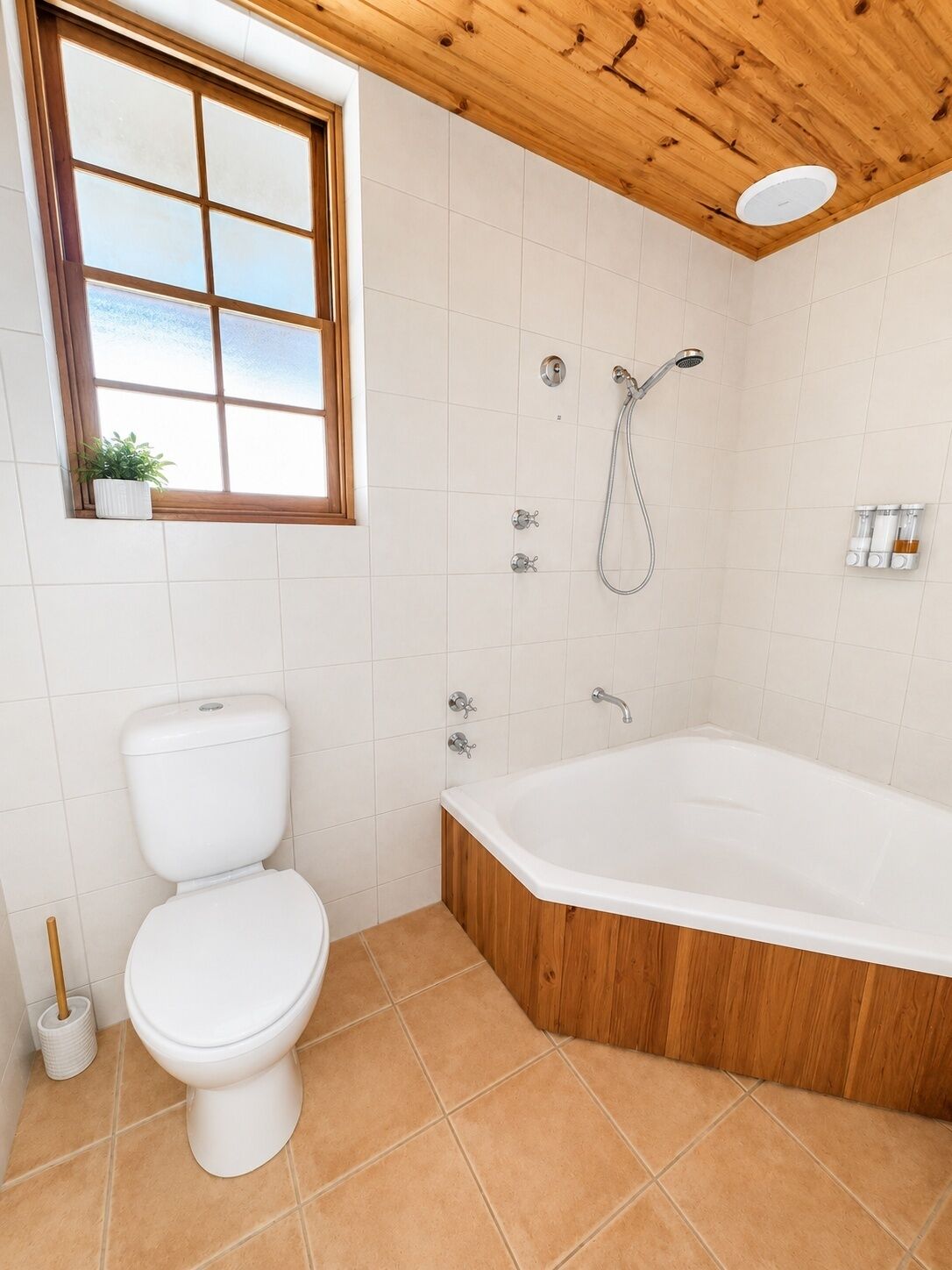 Un baño con inodoro, bañera, ducha y ventana.