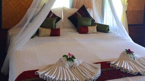 Un lit à baldaquin, avec des oreillers et une disposition décorative des serviettes.