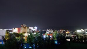 Un paisaje urbano nocturno con edificios y árboles iluminados.